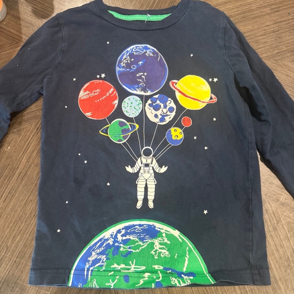 Boden astronaut holding planet balloons shirt